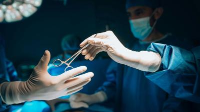 surgeon-handing-surgical-tool-in-operating-room.jpg