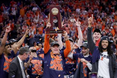 Illinois head coach Brad Underwood hoists the trophy with his team after defeating Iowa, 71-59, in the Elite Eight round of the NCAA Tournament at Toyota Center on Saturday, March 28, 2026, in Houston.