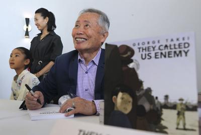 George Takei smiles as he autographs his book "They Called Us Enemy," during the Never Forget, Our 90th Anniversary Gala, put on by the San Diego Japanese American Citizens League, at the Town& Country Hotel and Convention Center on Sept. 14, 2019, in S...