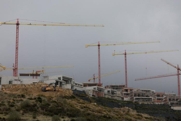 FILE PHOTO: Cranes are seen over houses under construction of La Finca de Jasmine, in Benahavis