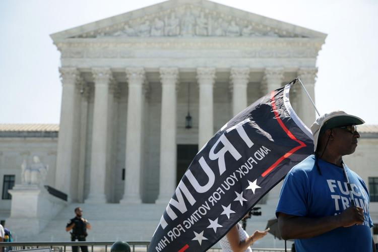 A man carries a flag in front of the U.S. Supreme Court on June 30, 2026, in Washington, D.C. Today, the U.S. Supreme Court struck down a ban on birthright citizenship, upheld state restrictions on transgender athletes in female sports and eliminated fe...