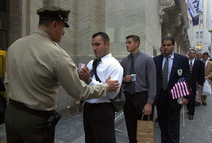 A security guard at the New York Stock Exchange checks employees on Sept. 17, 2001, for proper identification as they wait to enter the building. Wall Street and the stock exchanges reopened after the 9/11 terrorist attacks.