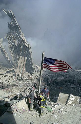 Three New York City firefighters raise an American flag at Ground Zero, site of the World Trade Center, on Sept. 11, 2001. The three firefighters from Brooklyn are George Johnson, Dan McWilliams and Billy Eisengrein.