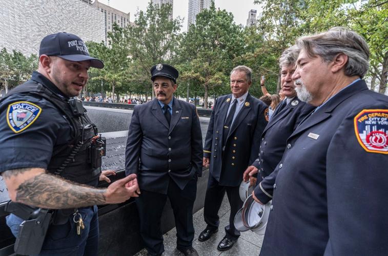 Port Authority Police Officer Zoran Perkovic, speaks with retired FDNY members James Efthimiades, Jim McGlynn, John Dunn and Jeffrey Coniglio at the 9/11 Memorial at the World Trade Center Aug. 5, 2026. On Sept. 11, 2001, after going back into the North To