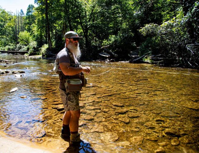 Pisgah Outdoors owner and operator Heath Cartee fly fishes in the South Mills River in the Turkey Pen area of Pisgah National Forest on Aug. 24, 2026. Cartee said sediment from road construction and logging could threaten fish habitat if protections under