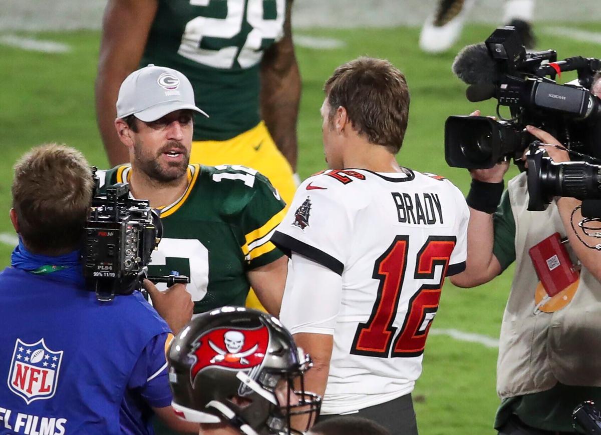 Aaron Rodgers, left, doesn't have the number of Super Bowl rings that Tom Brady does, yet the Packers quarterback can boast bigger numbers on his NFL paycheck.