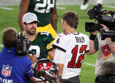 Aaron Rodgers, left, doesn't have the number of Super Bowl rings that Tom Brady does, yet the Packers quarterback can boast bigger numbers on his NFL paycheck.