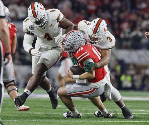 Miami Hurricanes defensive lineman Rueben Bain Jr. and defensive lineman Akheem Mesidor sack Ohio State Buckeyes quarterback Julian Sayin during the first half of the College Football Playoff quarterfinal game in the Cotton Bowl at AT&T Stadium in Arlin...