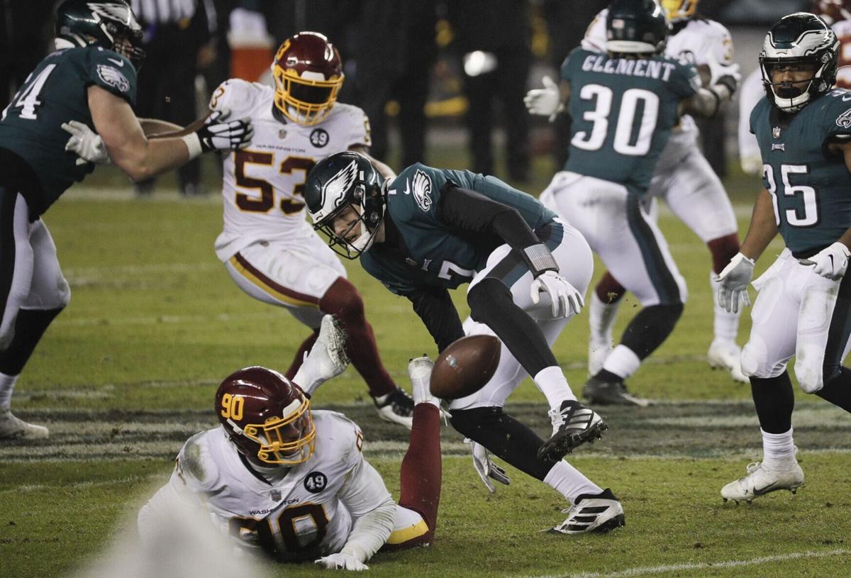 Eagles quarterback Nate Sudfeld fumbles the football against Washington Football Team defensive end Montez Sweat during the fourth quarter on Sunday, January 3, 2021 in Philadelphia.
