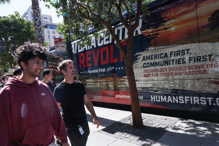 Conservative AI safety group Humans First parks their bus with a message against data centers outside of OpenAI headquarters