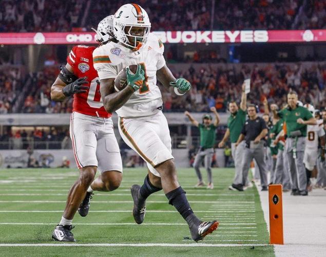 Miami Hurricanes running back Mark Fletcher Jr. scores as Ohio State Buckeyes linebacker Sonny Styles gives chase during the first half of the College Football Playoff quarterfinal game in the Cotton Bowl at AT&T Stadium in Arlington, Texas on Wednesday...