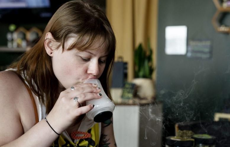 Emily Groessl inhales Cannabis smoke from a snifter at Holistic Connection in Nashville on May 11, 2022.