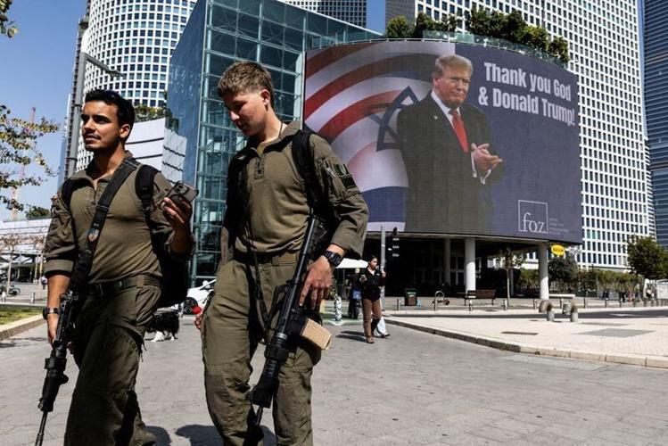 FILE PHOTO: People walk by a billboard commissioned by an evangelical group, amid the U.S.-Israel conflict with Iran, in Tel Aviv