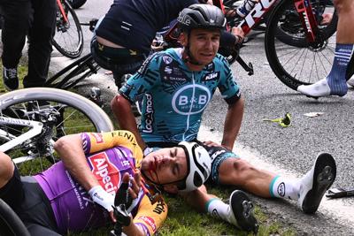 Team B&B KTM's Bryan Coquard of France, right, and a Team Alpecin Fenix' rider lie on the ground after crashing during the first stage of the 108th edition of the Tour de France cycling race, 197 km between Brest and Landerneau, on Saturday, June 26, 2021.