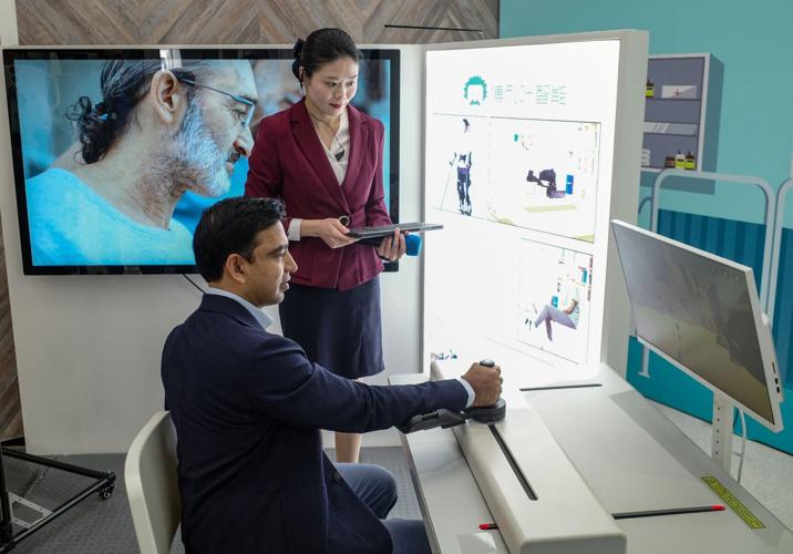 A man controls a medical robot during a tour for foreign invetors, in Shanghai