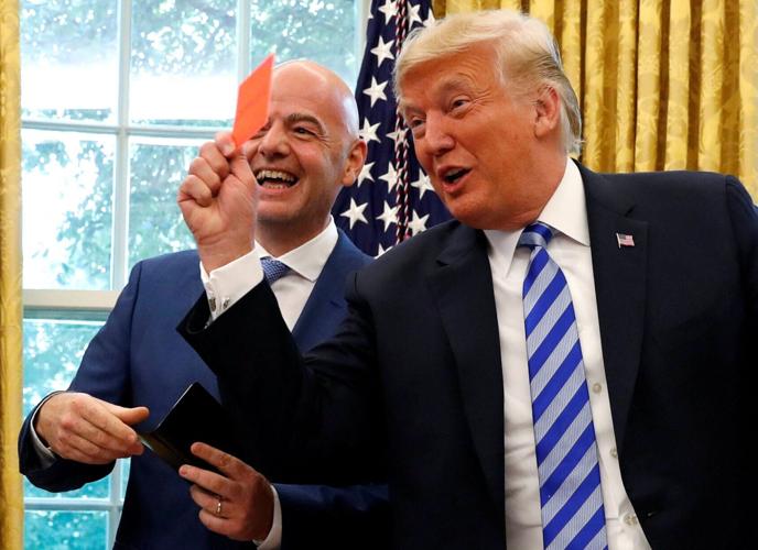 FILE PHOTO: U.S. President Donald Trump holds red card as he meets with FIFA President Infantino in the Oval Office of the White House in Washington