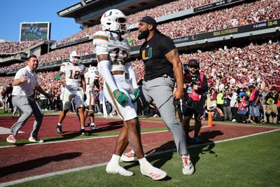 Miami's Bryce Fitzgerald celebrates with safeties coach Will Harris after intercepting a pass in the fourth quarter against Texas A&M during the a College Football Playoff first-round game at Kyle Field on Saturday, Dec. 20, 2025, in College Station, Te...