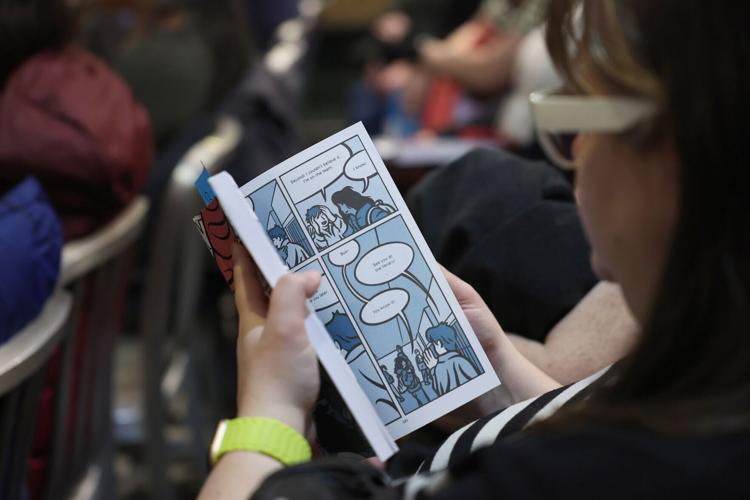 Educator Beth Hetland flips through librarian and author Jarrett Dapier's graphic novel, "Wake Now in the Fire," before a discussion of the book at The Book Cellar, 4736 N. Lincoln Ave., Tuesday, Feb. 3, 2026, in Chicago.