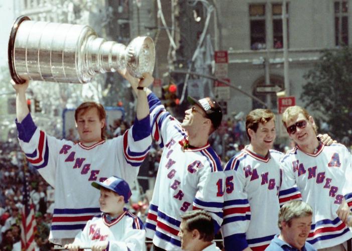 New York Rangers Mark Messier, Adam Graves, Mike Richter, Brian Leetch, Steve Larmer and Kevin Lowe take turns lifting the Stanley Cup on the lead float as over a million fans lined the Canyon of Heroes on Broadway during the Rangers ticker-tape parade ...