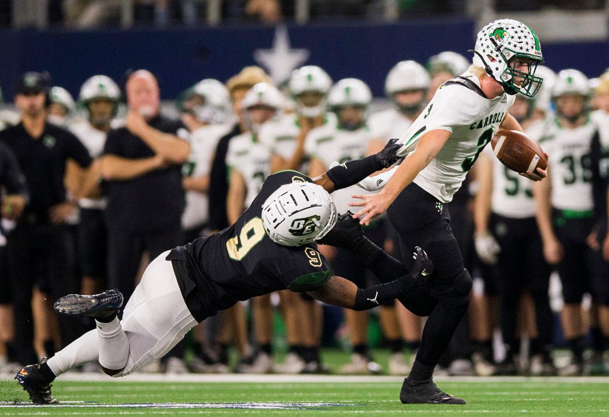 Southlake Carroll quarterback Quinn Ewers is pulled down by DeSoto linebacker Ridarius Branch during the second quarter of a Class 6 A Division I area-round high school football playoff game between Southlake Carroll and DeSoto on Friday, November 22, 2019 at AT&T Stadium in Arlington.
