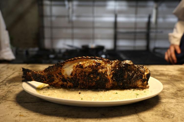 A lionfish with risotto is served on a plate in a restaurant in the coastal city of Limassol
