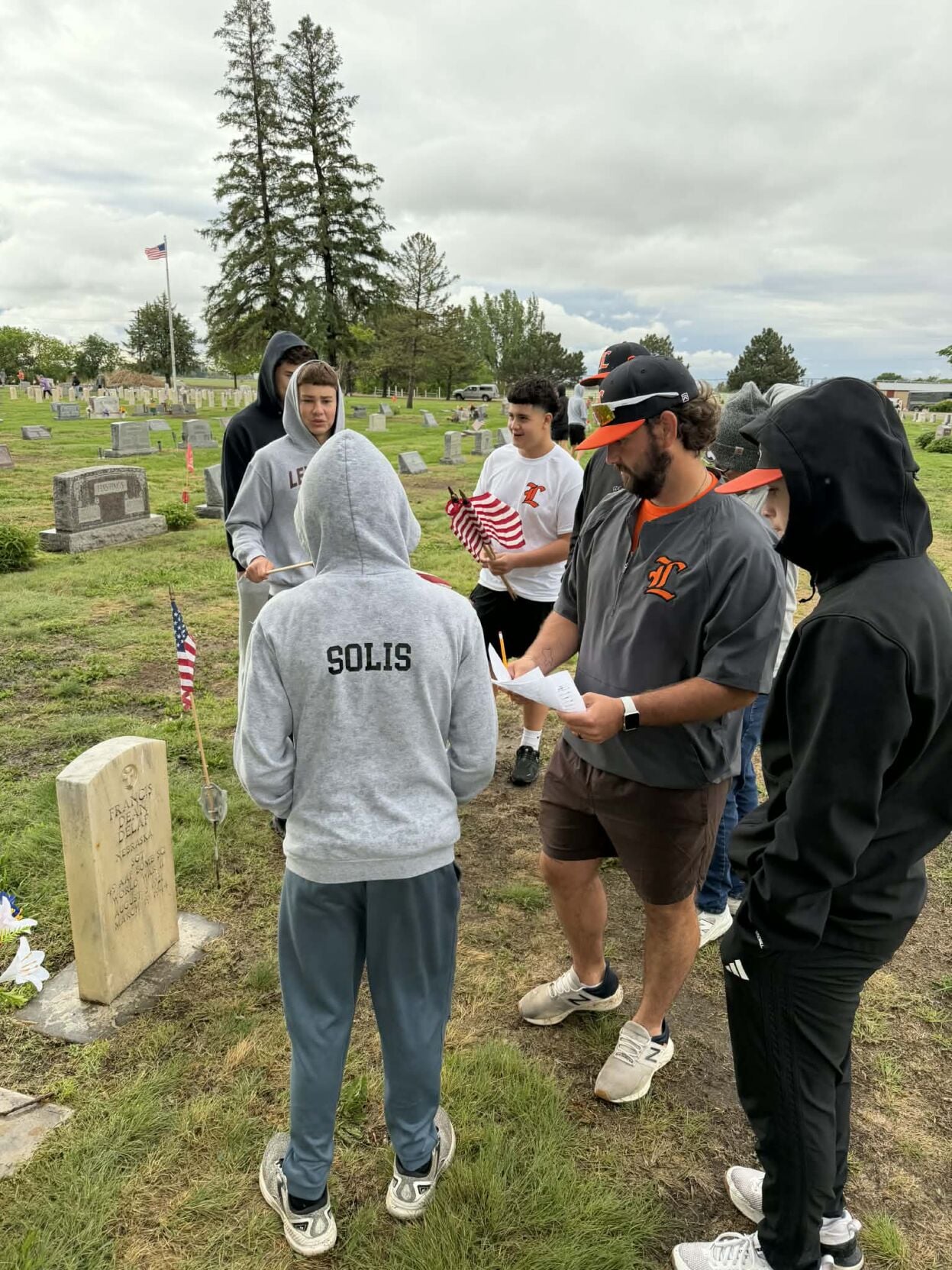 Baseball teams place flags for Veterans at Lexington cemeteries