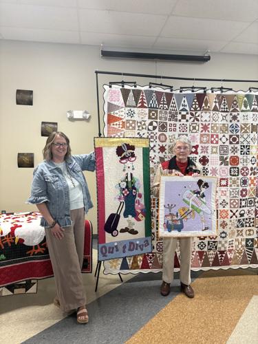Whithuhn and Geiger in front of Dear Jane quilt
