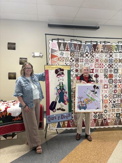 Whithuhn and Geiger in front of Dear Jane quilt