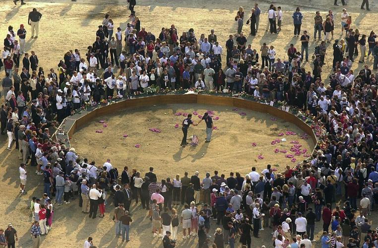 Two family members of 9/11 victims shake hands on Sept. 11, 2002 after laying flowers in the middle of a circle set up at Ground Zero on the first anniversary of the World Trade Center attacks.