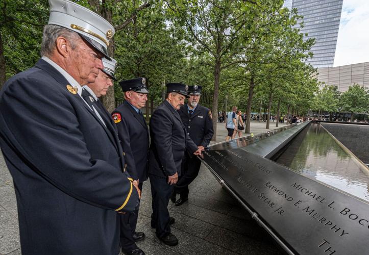 While visiting the 9/11 Memorial at the World Trade Center Aug. 5, 2026, retired FDNY firefighters Jim McGlynn, John Drumm, Robert Bacon, James Efthimiades and Jeffrey Coniglio, look at names of their fellow firefighters who died in the Sept. 11 attacks.at