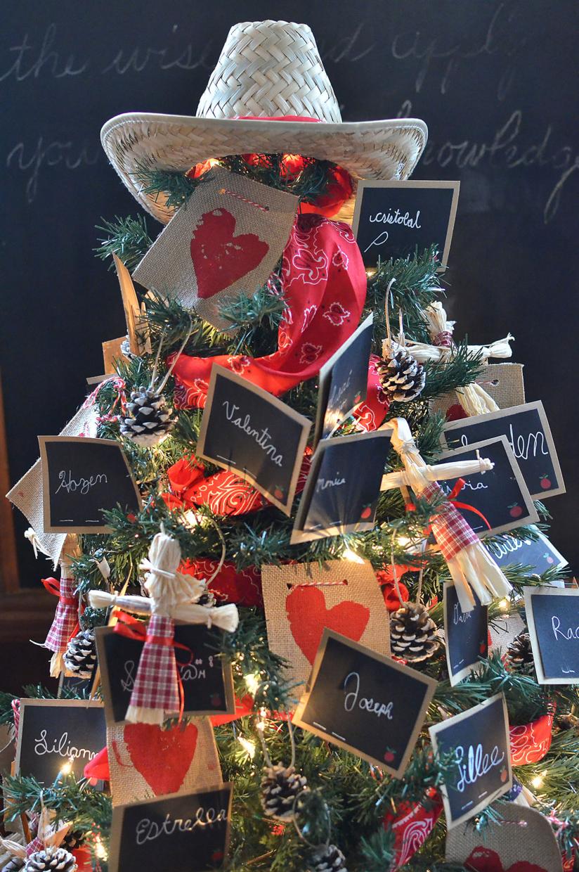 Handmade ornaments and miniature chalkboards with students names decorate a pioneer style Christmas tree at the Calaveras School during the Festival of