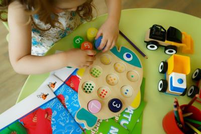 A child, of preschool or elementary, age plays with toys