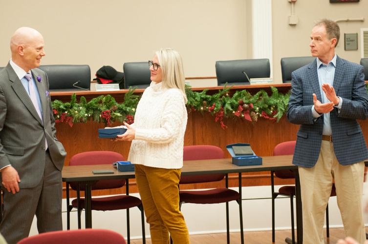 Council member Erin Rayner presents outgoing council member Tip Stinnette with a gift at the town council’s last scheduled meeting of year Dec. 13, 2022.