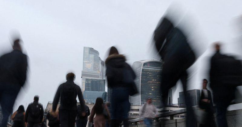 FILE PHOTO: Workers cross London Bridge during the morning rush-hour in London