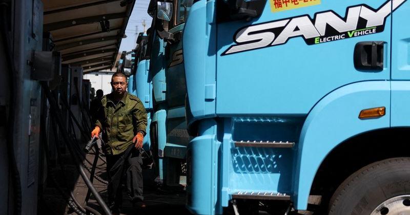FILE PHOTO: Driver charges a Sany electric heavy truck at a fleet depot equipped with electric truck charger, in Tangshan