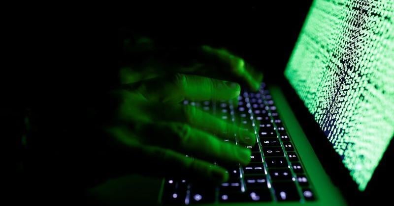 Man types on a computer keyboard in front of the displayed cyber code in this illustration picture