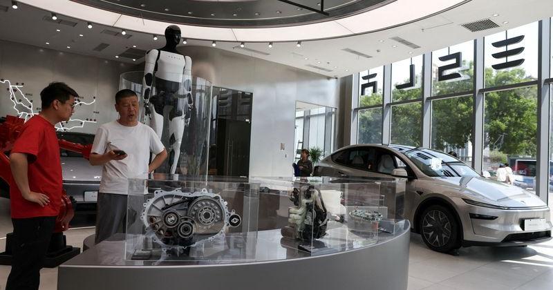 FILE PHOTO: Staff member attends to a customer inside a Tesla store at a shopping mall in Beijing