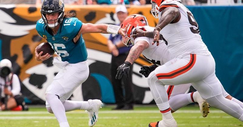 Jacksonville Jaguars quarterback Trevor Lawrence (16) tries to elude Cleveland Browns defensive tackle Mason Graham (94) in the