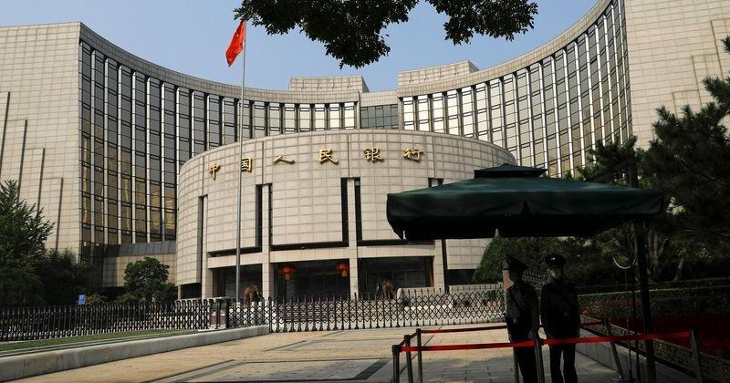 Paramilitary police officers stand guard in front of the headquarters of PBOC in Beijing