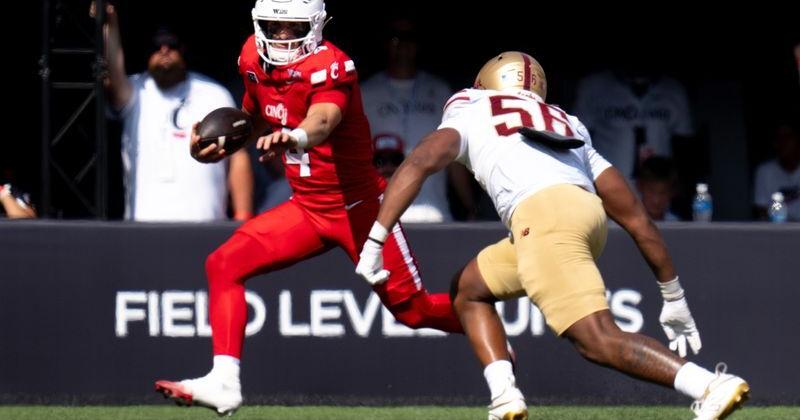 Cincinnati Bearcats quarterback JC French IV (4) runs the ball as Boston College Eagles defensive lineman E'Lla Boykin (56)