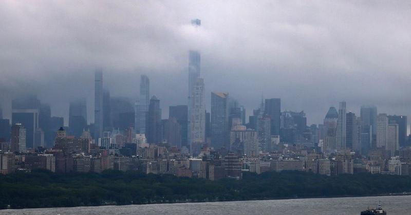Rain clouds over the New York City skyline and the Hudson River are seen from Fort Lee