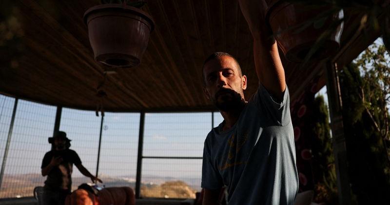 Marmar Ouda's son Mohamed in front of metal bars installed to protect the family from militant settler attacks in the Palestinian village Qusra