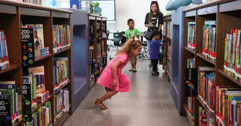 In this 2024 file photo, Allison Curran, who was about to start kindergarten, runs though bookshelves in the library at Creekside Elementary School. Creekside earned an A rating from the state for the 2025-26 school year.