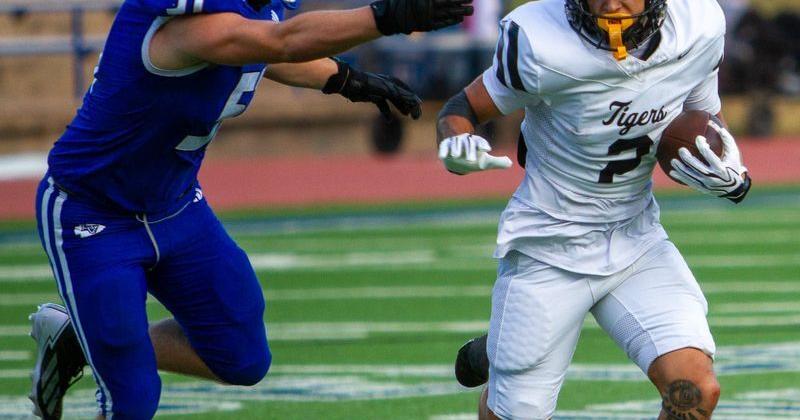 Snyder football's Tyson Burleson (2) runs with the ball and attempts to escape the pursuit from Lake View's Conner Williams (51) in a game at San Angelo Stadium on Friday, Sept. 4, 2026.
