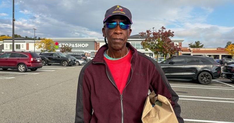 Tyrone Benjamin holds a paper grocery bag in front of a Stop and Shop store in Peekskill
