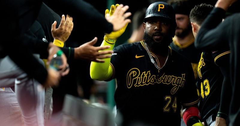 Pittsburgh Pirates designated hitter Marcell Ozuna (24) high fives teammates after scoring on a base hit by Pittsburgh Pirates