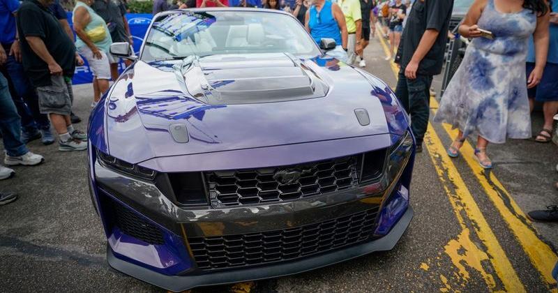 Onlookers check out the new Ford Mustang Dark Horse SC Convertible after it was lowered from a crane to help kick off the 2026 Woodward Dream Cruise  on Friday, Aug. 14, 2026 in Ferndale.