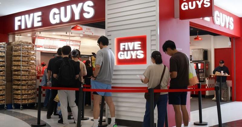 People queue at a Five Guys fast-food restaurant, in Beijing