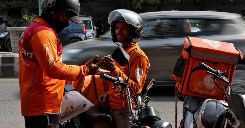 FILE PHOTO: Gig workers prepare to deliver orders outside Swiggy's grocery warehouse, in New Delhi