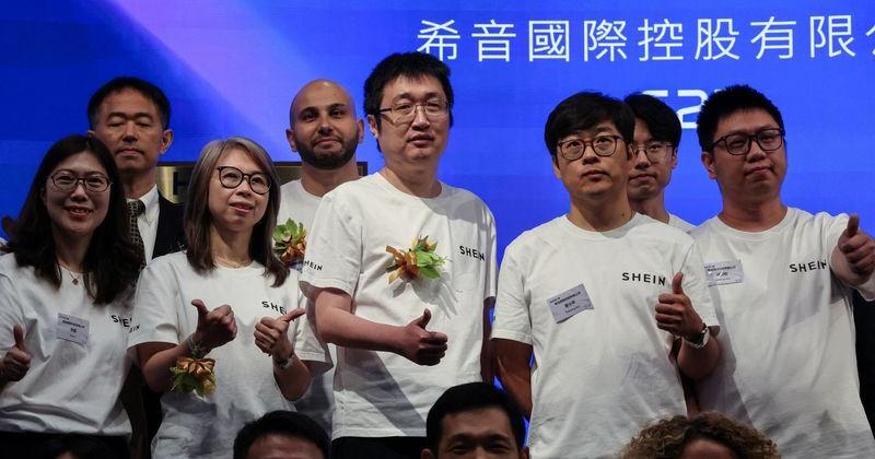 Founder and chairman of online retailer Shein Xu Yangtian, also known as Sky Xu or Chris Xu, poses for photos with staff members at the company's listing ceremony at the Hong Kong Stock Exchange, in Hong Kong